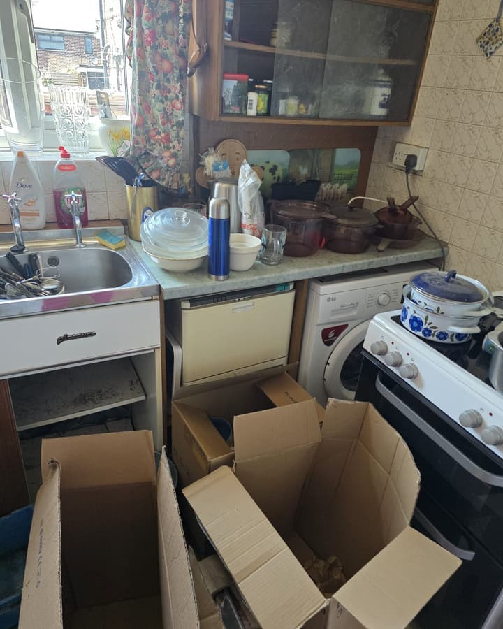 A kitchen part way through a clearance, with boxes being packed